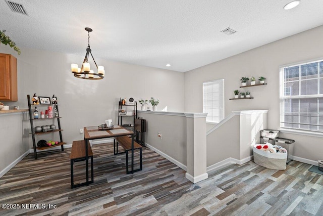 office with a textured ceiling, dark wood-type flooring, and an inviting chandelier