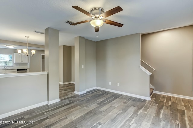 unfurnished living room with hardwood / wood-style floors, ceiling fan with notable chandelier, and sink