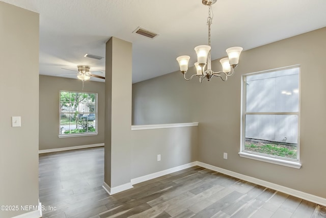 unfurnished room featuring wood-type flooring and ceiling fan with notable chandelier