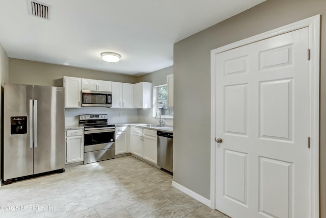 kitchen with white cabinets, sink, and appliances with stainless steel finishes