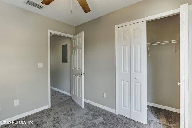 unfurnished bedroom featuring carpet flooring, ceiling fan, electric panel, and a closet