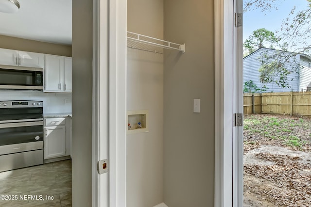 clothes washing area with washer hookup and light tile patterned floors