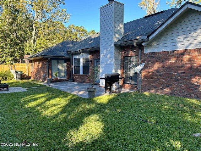 rear view of property featuring a yard and a patio