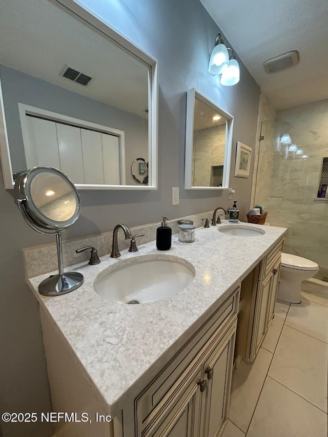 bathroom with tile patterned flooring, vanity, and toilet