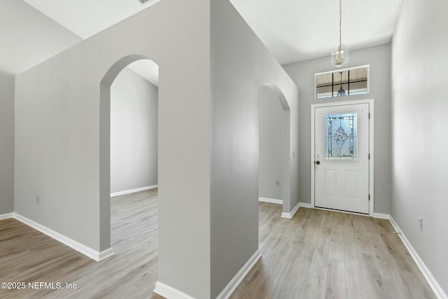 entrance foyer with light hardwood / wood-style floors and a high ceiling