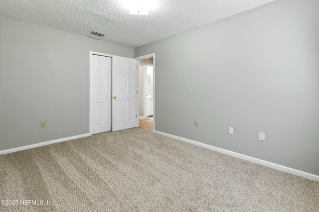 unfurnished bedroom with a closet, carpet, and a textured ceiling