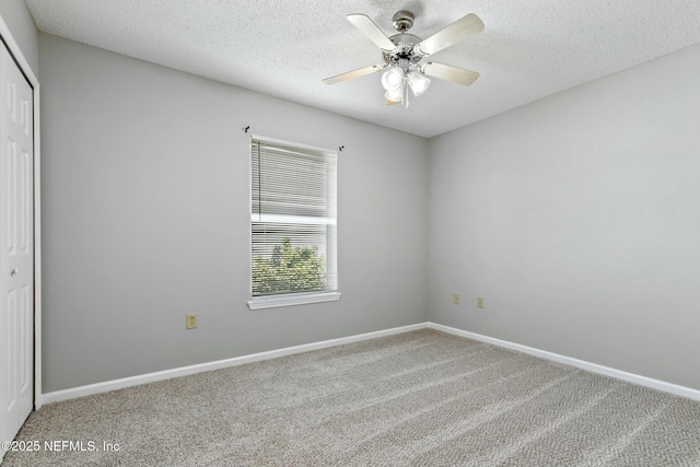 carpeted empty room featuring ceiling fan and a textured ceiling