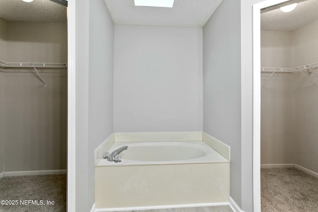 bathroom with a bathing tub and a textured ceiling