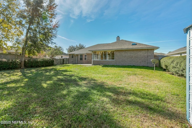 back of house featuring a lawn