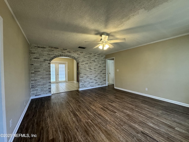 unfurnished room with ceiling fan, french doors, dark hardwood / wood-style floors, crown molding, and a textured ceiling