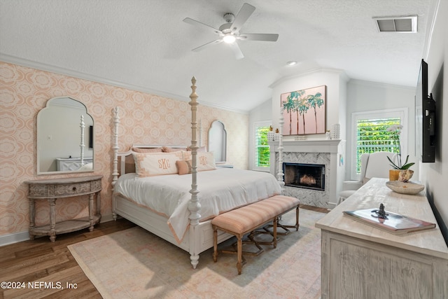 1669 Linkside Ct N, Atlantic Beach, FL 32233 - bedroom featuring wallpapered walls, light wood-style floors, baseboards, vaulted ceiling, and a high end fireplace