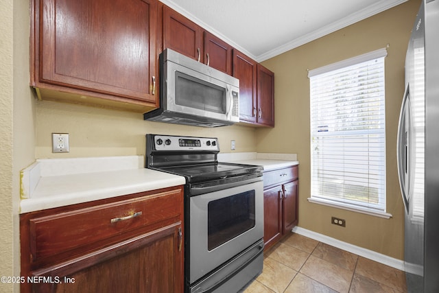 kitchen featuring light tile patterned floors, stainless steel appliances, crown molding, and a wealth of natural light