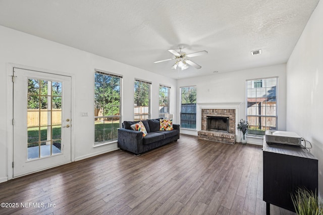 living room with a wealth of natural light, ceiling fan, and dark hardwood / wood-style flooring