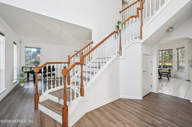 staircase featuring wood-type flooring and ornamental molding