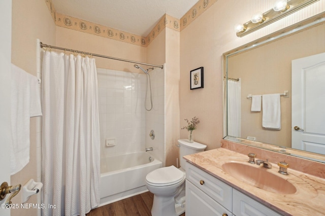 full bathroom featuring hardwood / wood-style floors, shower / bath combination with curtain, a textured ceiling, toilet, and vanity