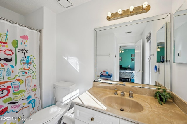 bathroom featuring ceiling fan, vanity, a textured ceiling, and toilet