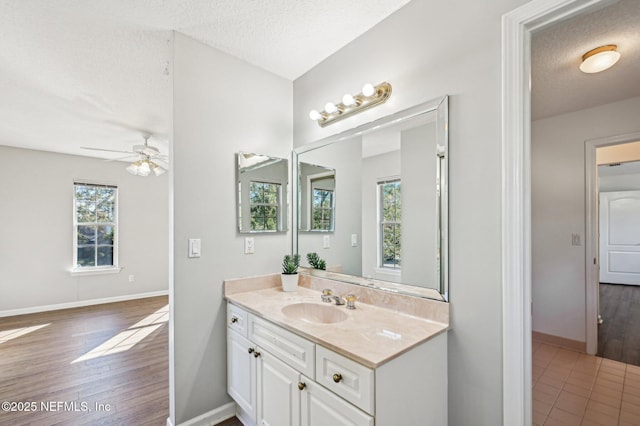 bathroom featuring a textured ceiling, vanity, and ceiling fan