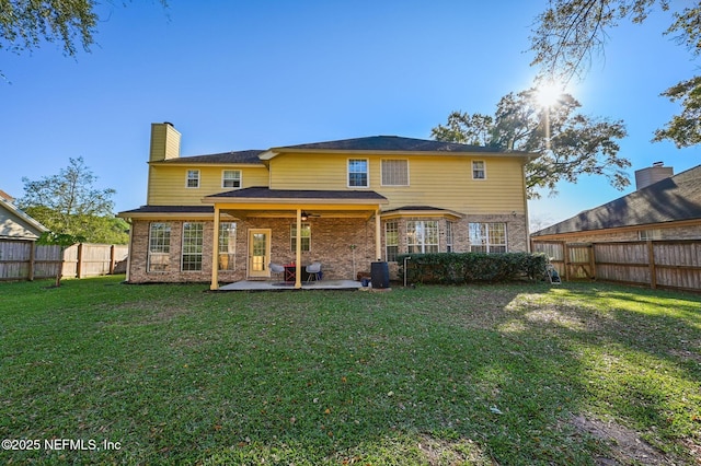 back of property with a patio area and a yard