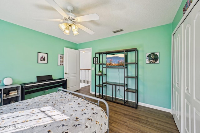 bedroom featuring ceiling fan, dark hardwood / wood-style floors, a textured ceiling, and a closet