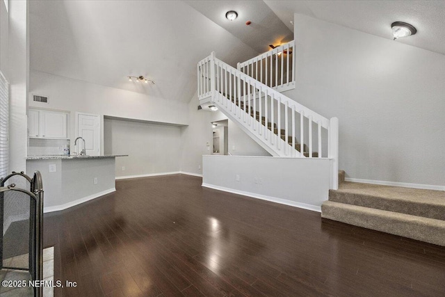 living room featuring dark hardwood / wood-style floors, sink, and high vaulted ceiling