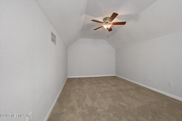 bonus room with light carpet, a textured ceiling, ceiling fan, and lofted ceiling