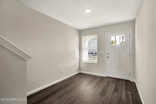 entryway with a textured ceiling and dark wood-type flooring