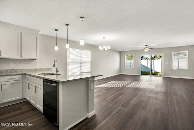 kitchen featuring white cabinetry, dishwasher, hanging light fixtures, and sink