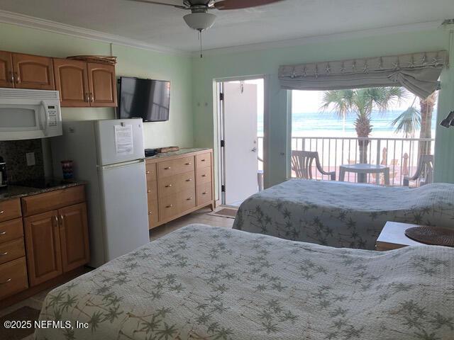 bedroom featuring access to exterior, white refrigerator, ceiling fan, and crown molding