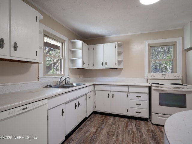 kitchen with white appliances, dark wood-type flooring, white cabinets, crown molding, and sink