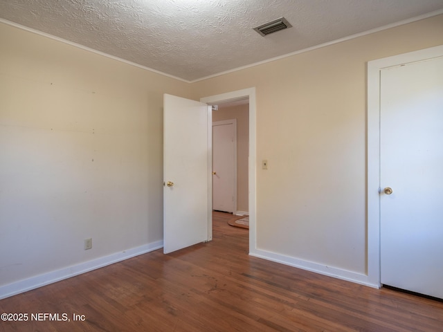 unfurnished bedroom with wood-type flooring, a textured ceiling, and ornamental molding