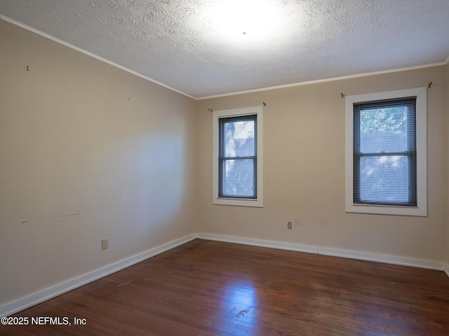 spare room with dark hardwood / wood-style floors, ornamental molding, and a textured ceiling