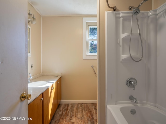 bathroom featuring vanity, wood-type flooring, ornamental molding, and bathtub / shower combination