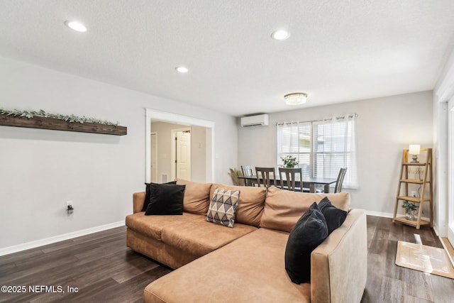 living room with dark hardwood / wood-style floors, an AC wall unit, and a textured ceiling