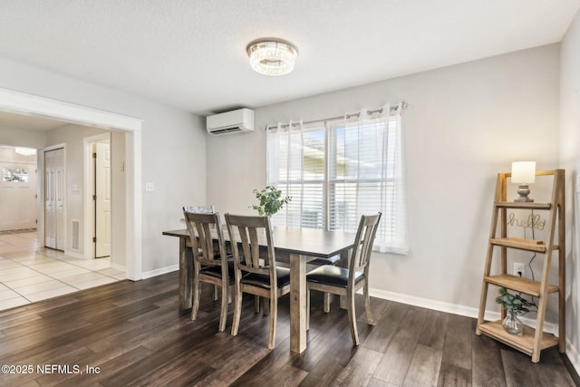 dining area with a wall mounted air conditioner and hardwood / wood-style floors