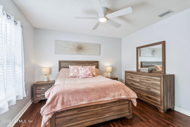 bedroom featuring ceiling fan, dark hardwood / wood-style floors, and a textured ceiling