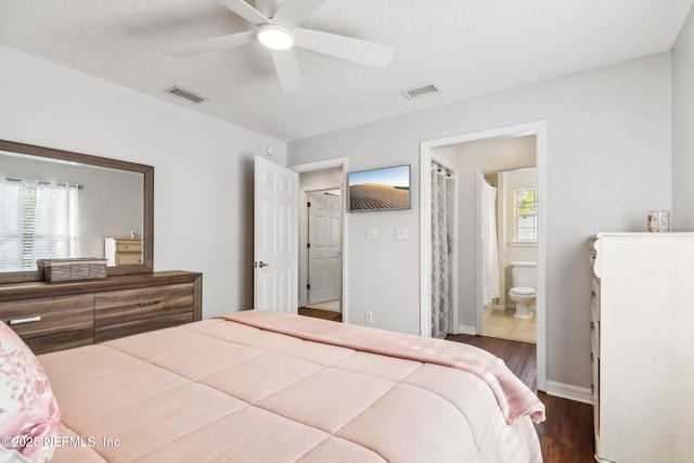 bedroom with connected bathroom, ceiling fan, dark hardwood / wood-style flooring, and a textured ceiling