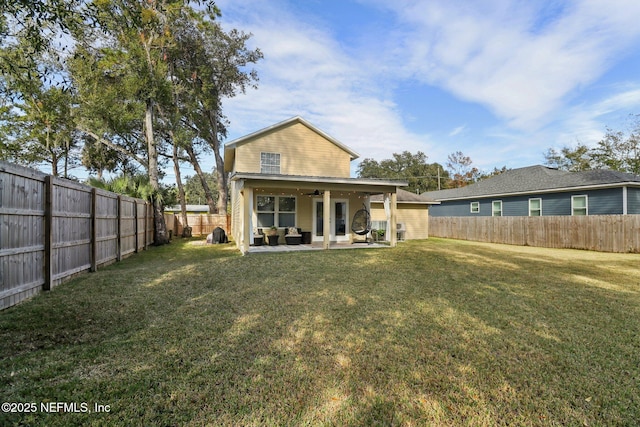 back of property with a lawn, ceiling fan, and a patio