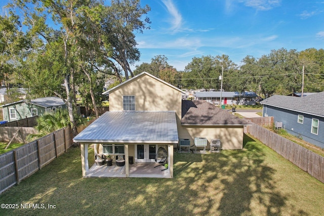 back of house with a yard and a patio