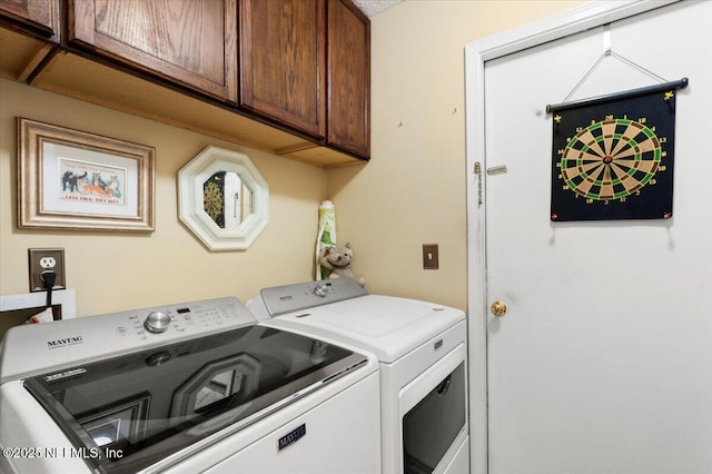 washroom featuring cabinets and washer and clothes dryer