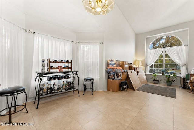 interior space with tile patterned flooring, vaulted ceiling, and a notable chandelier