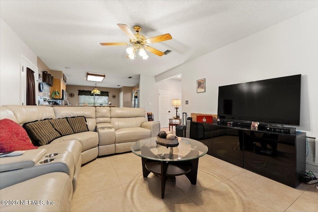 living room featuring a textured ceiling, ceiling fan, and light tile patterned flooring