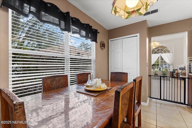 tiled dining area featuring a notable chandelier