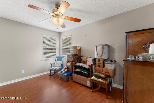 sitting room featuring wood-type flooring, a textured ceiling, and ceiling fan