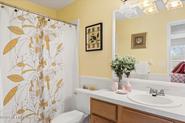 bathroom with vanity, a textured ceiling, and toilet