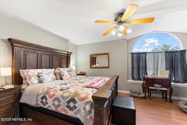 bedroom featuring a textured ceiling, light hardwood / wood-style floors, and ceiling fan