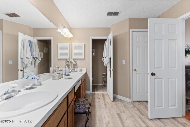 bathroom featuring vanity, a textured ceiling, and hardwood / wood-style flooring