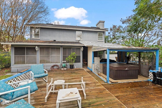 deck with a sunroom and a hot tub