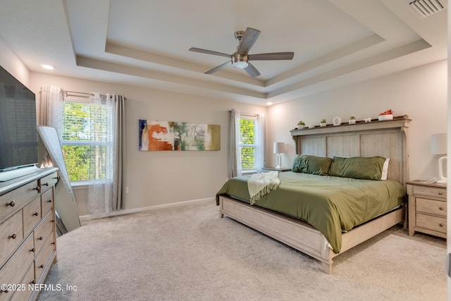 bedroom featuring a tray ceiling, ceiling fan, and light colored carpet