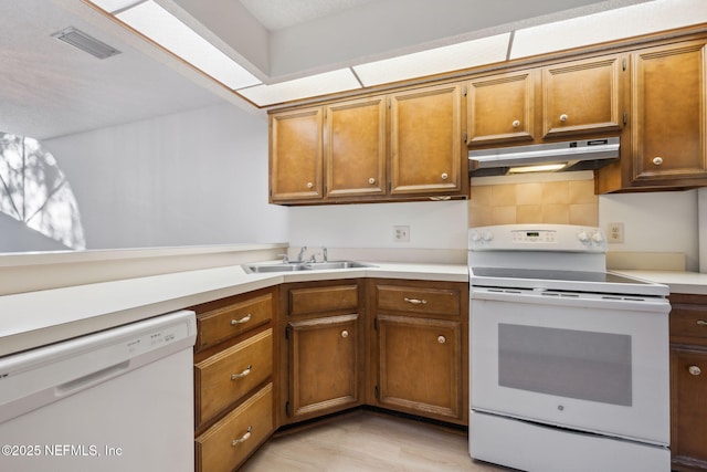 kitchen with white appliances, light hardwood / wood-style flooring, and sink