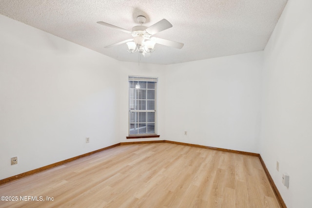 spare room featuring ceiling fan, light wood-type flooring, and a textured ceiling